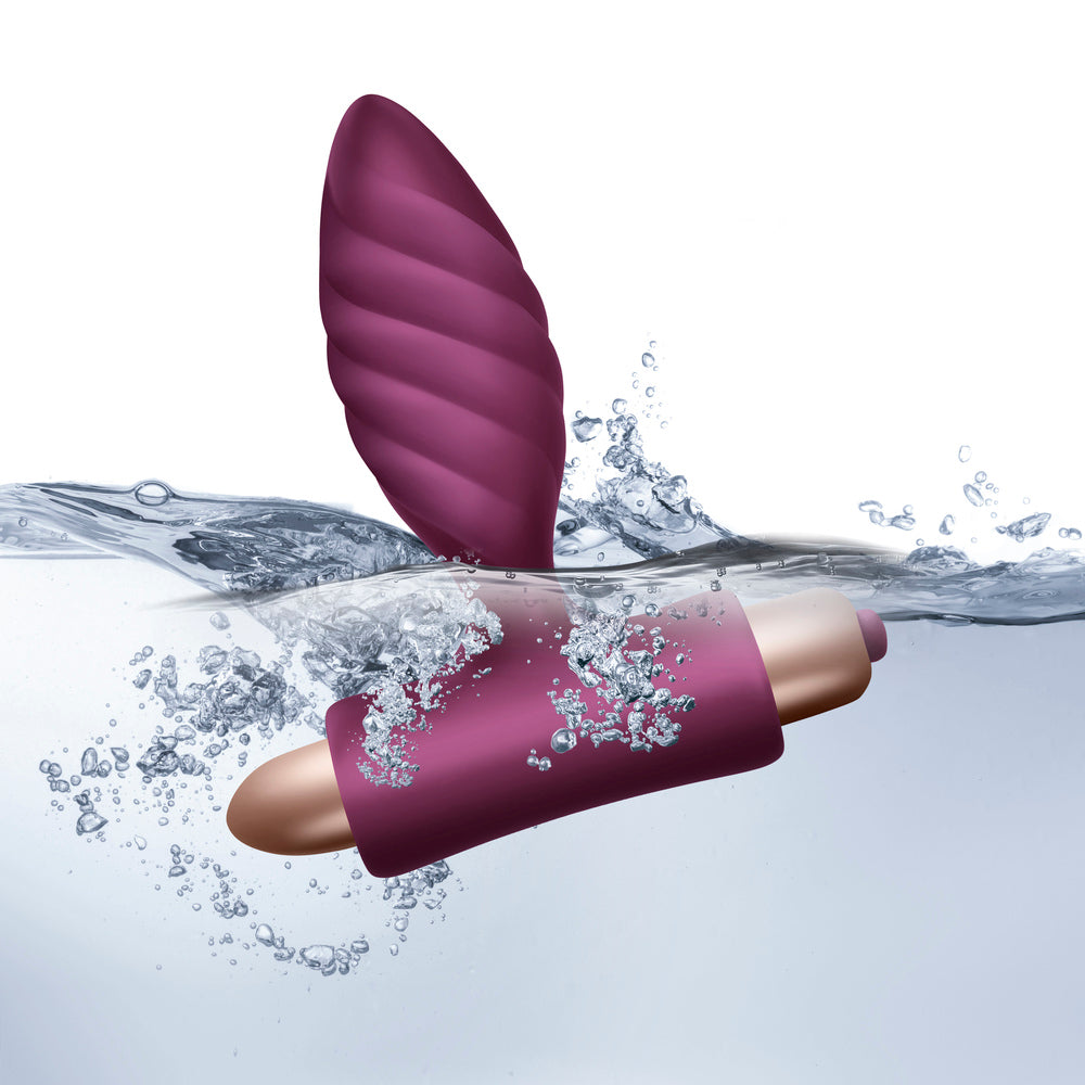 Rocks Off Oryx anal plug, plum, gold, partially submerged in water.