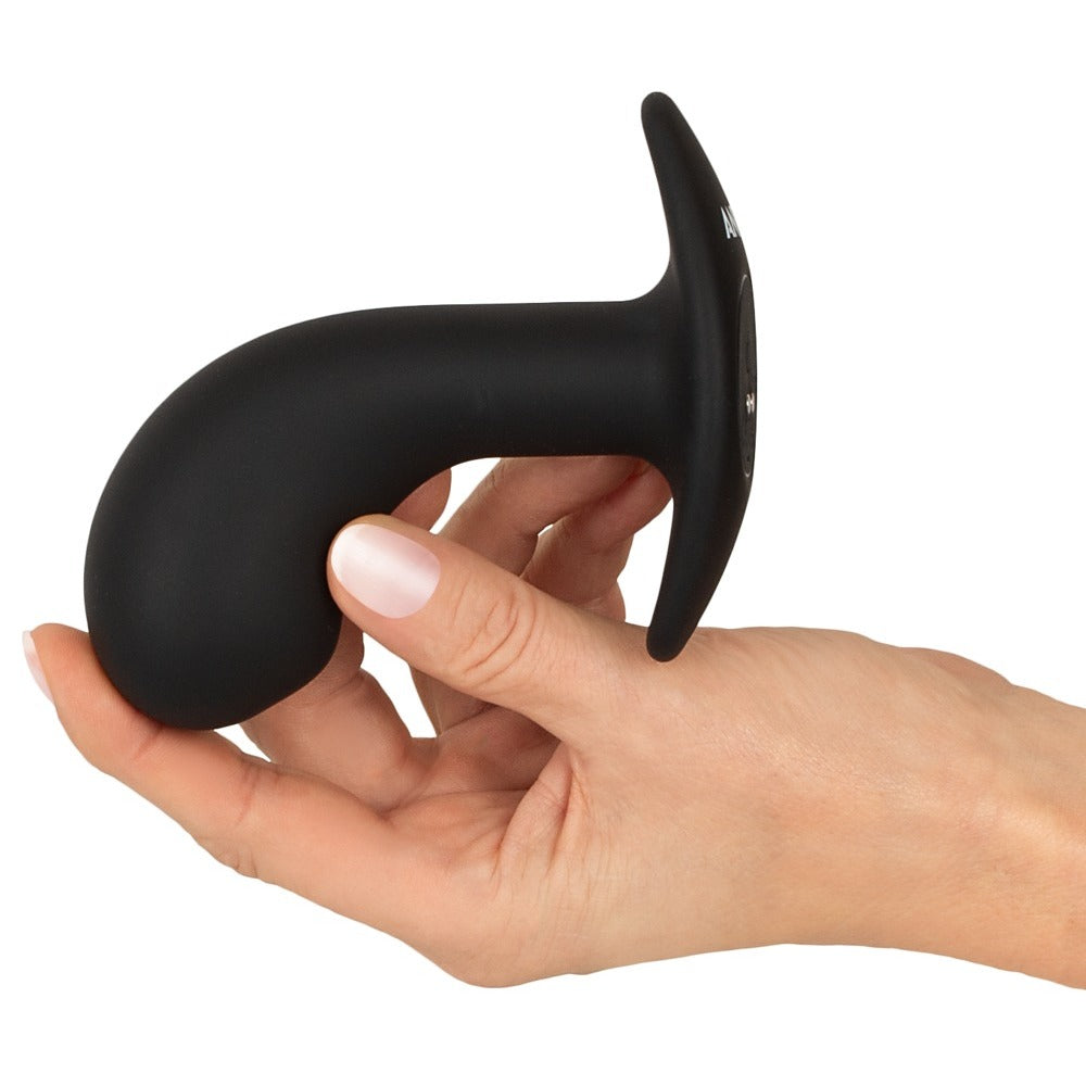 Black prostate plug held in a hand.