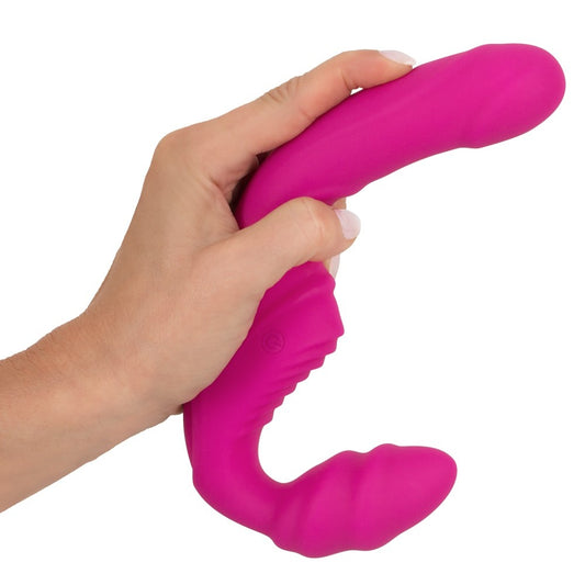 Pink vibrating strapless strap-on dildo held in hand