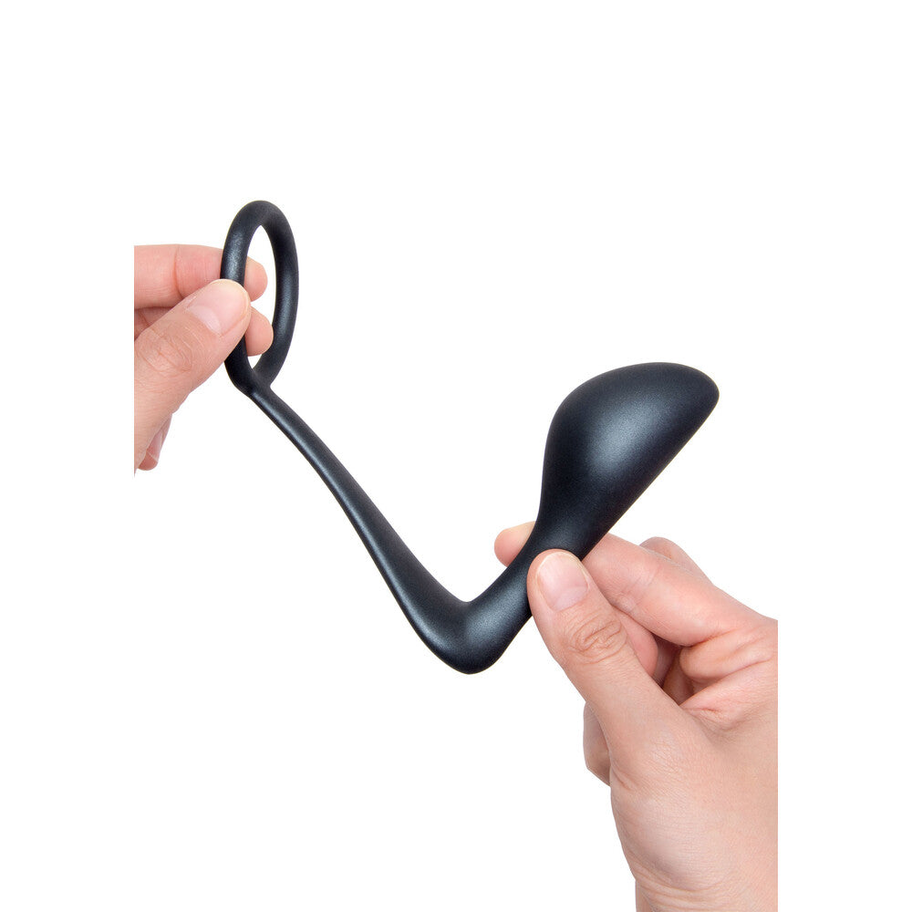 B-Vibe Ringer: A black cock ring with plug, playfully held for a sensual exploration. Unlock your pleasure potential!