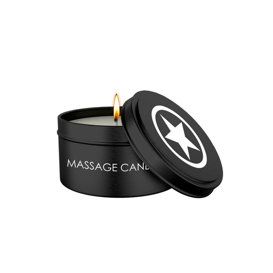 Black massage candle with the lid ajar, revealing a flickering flame.