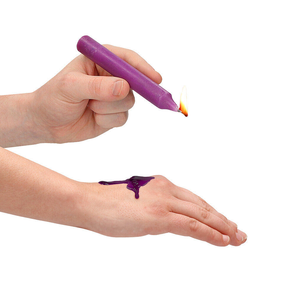Purple teasing wax being dripped onto a hand.
