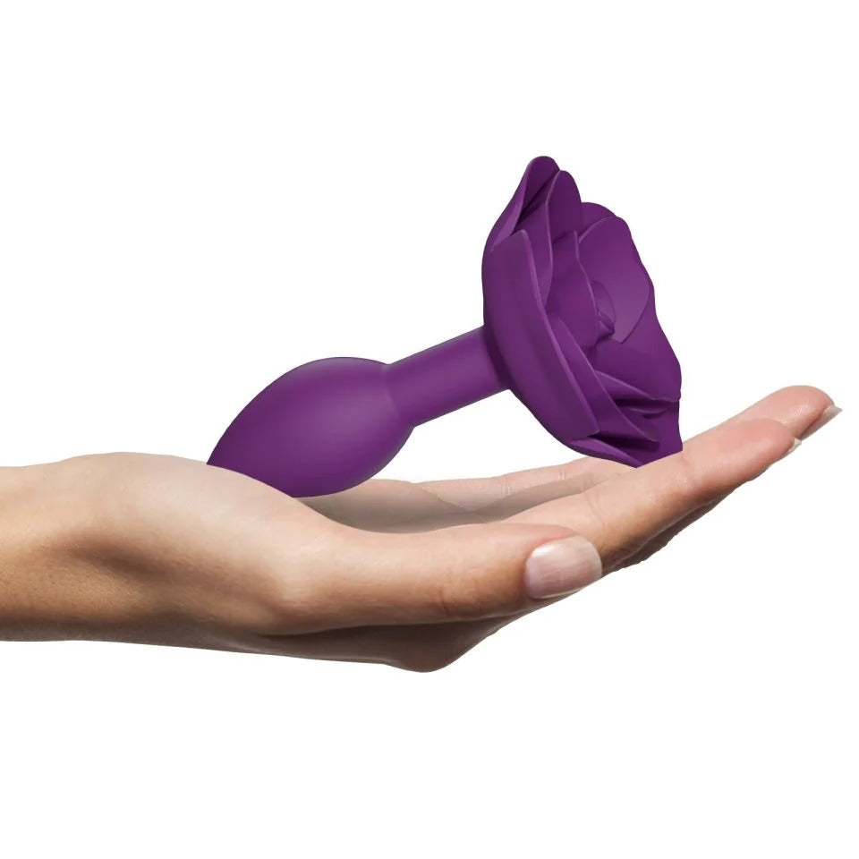 Purple rose butt plug resting on a hand.