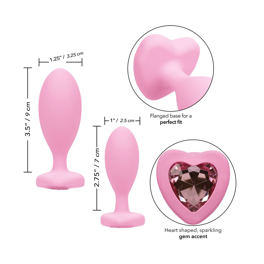 Pink butt plugs with flanged base and heart gem.