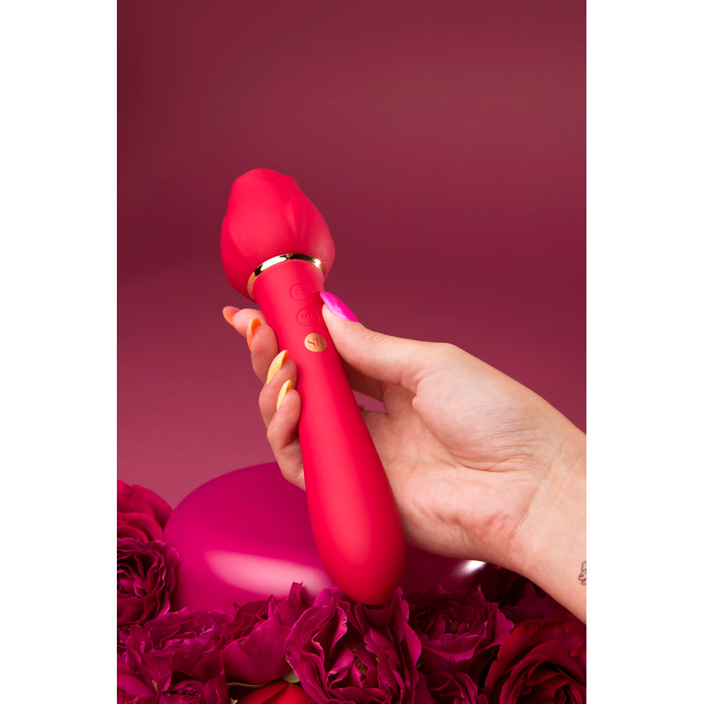 Secret Kisses Rosegasm Lingo in use. Rose-shaped vibrator held above red roses, ready for a sensual moment.