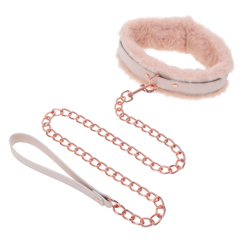 Flirty fur collar with rose gold chain leash from Sportsheets. Playfully explore your sensual side with this delightful accessory.