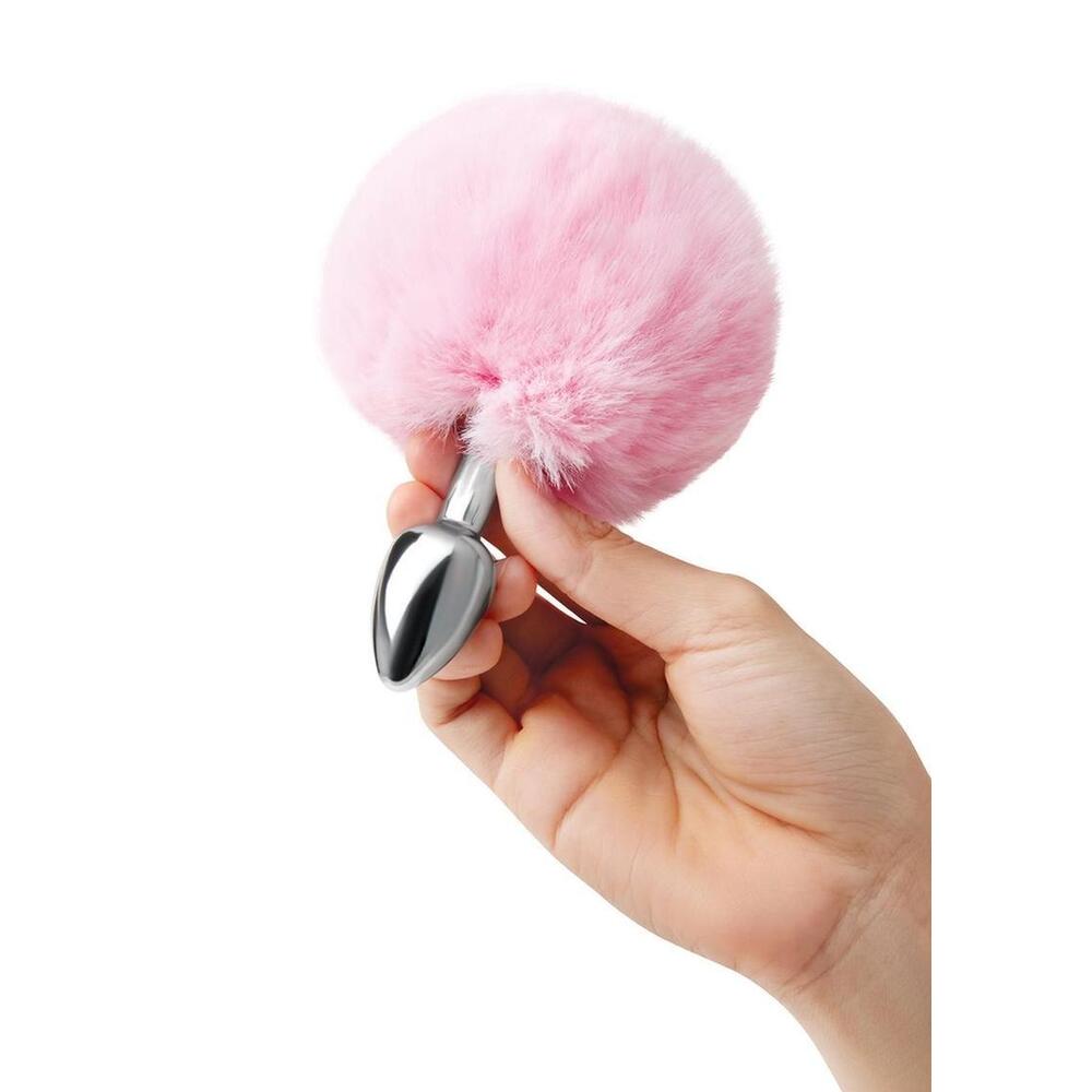 Hand holding a pink bunny tail butt plug.