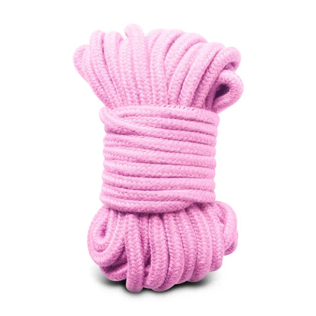 Blush pink cotton rope, coiled tight. Ready for a playful embrace, darling? Just imagine the possibilities...
