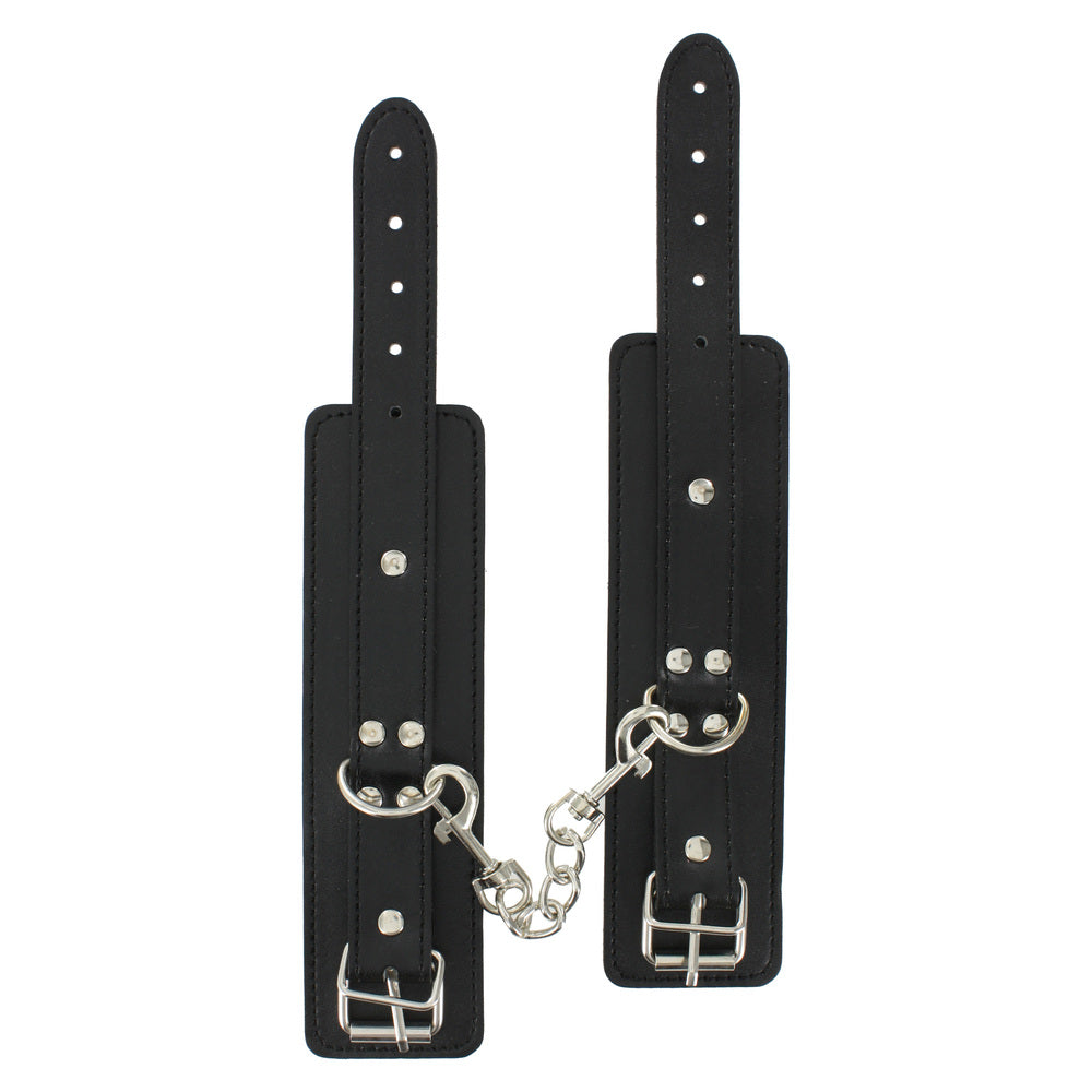 Black leather wrist restraints linked with chain.