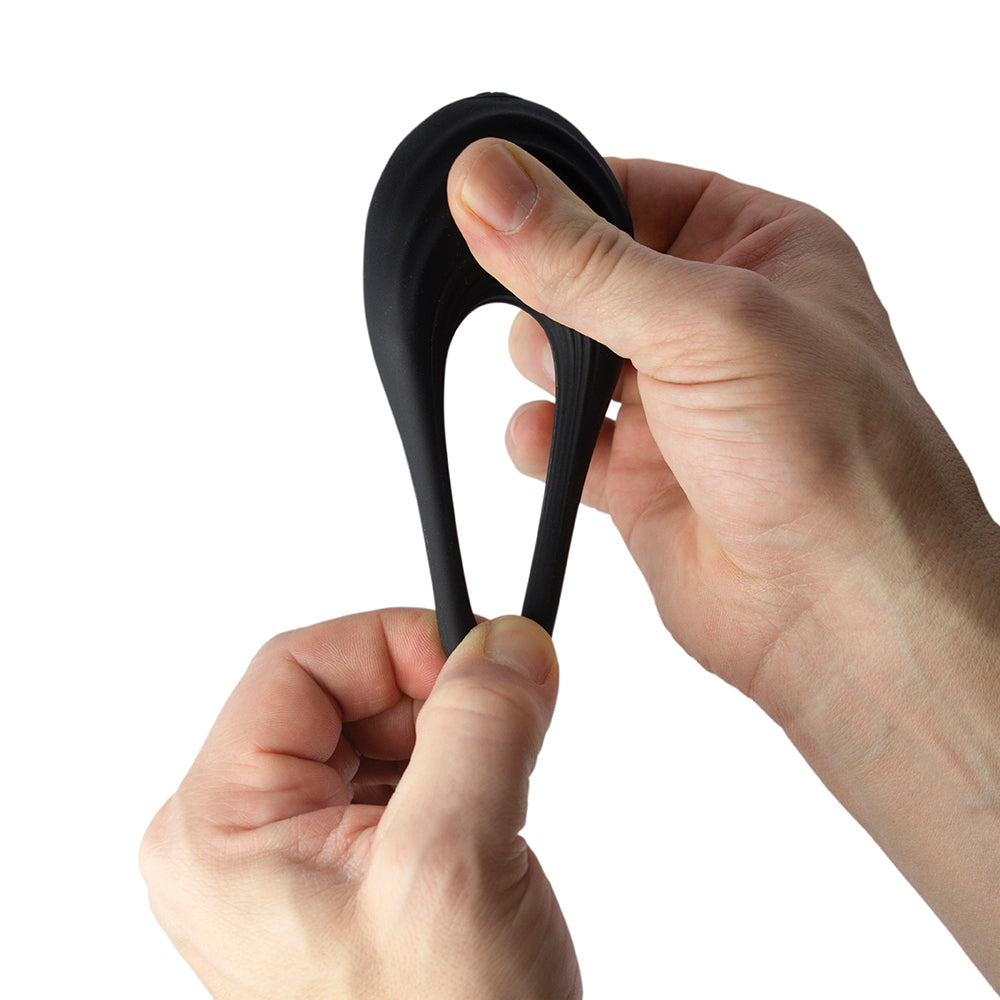 Black silicone cockring being stretched