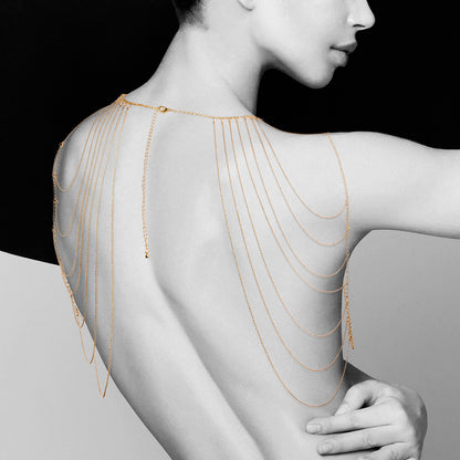 Golden whispers grace her back. The Bijoux Indiscrets shoulder jewellery, a cascade of allure.
