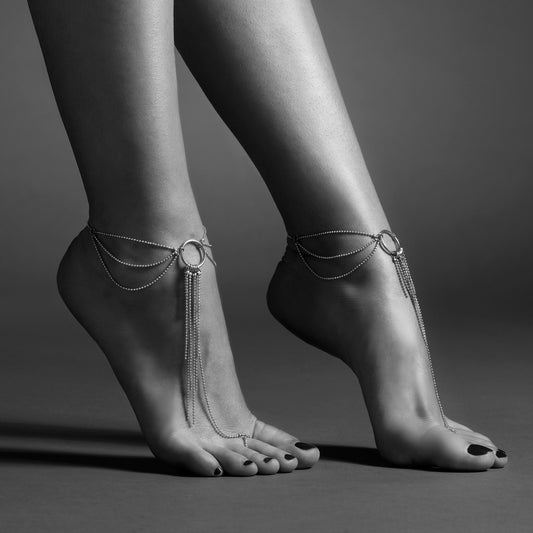 Bare feet adorned with Bijoux Indiscrets foot chains. Silver elegance trails from ankle to toe, a delicate and playful dance.
