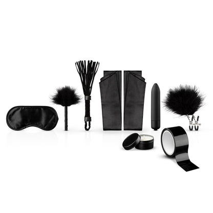 Black kinky starter kit including blindfold, flogger, tickler, restraints, bullet vibrator, nipple clamps, candle and tape.