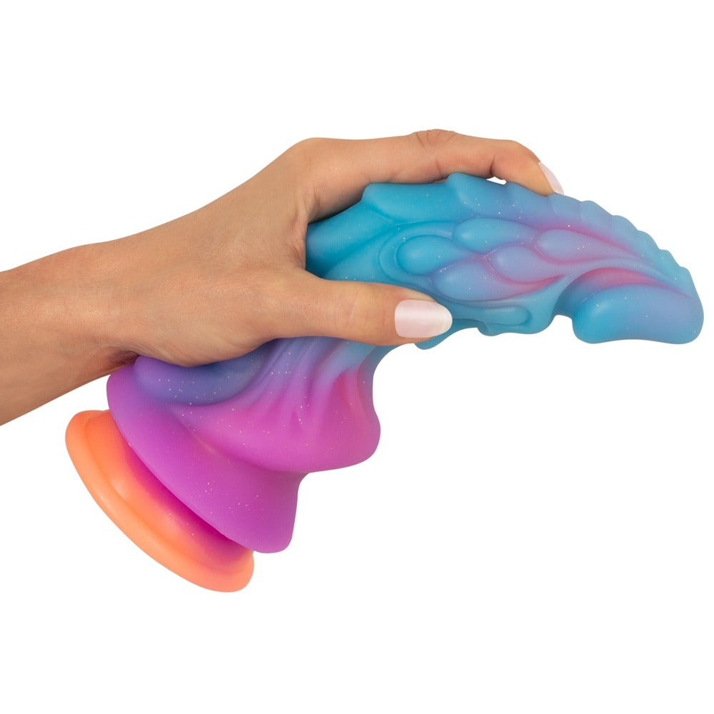 Hand holding a colourful fantasy-inspired dildo.