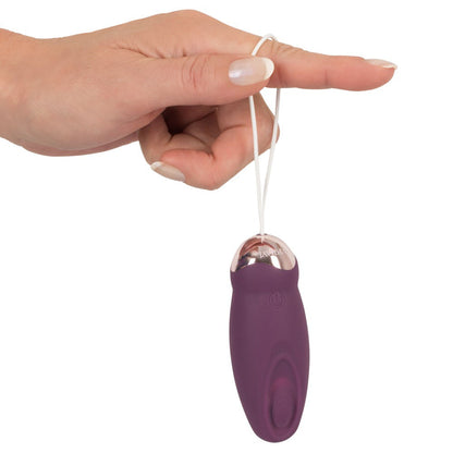 Hand holds purple Javida rechargeable love ball.