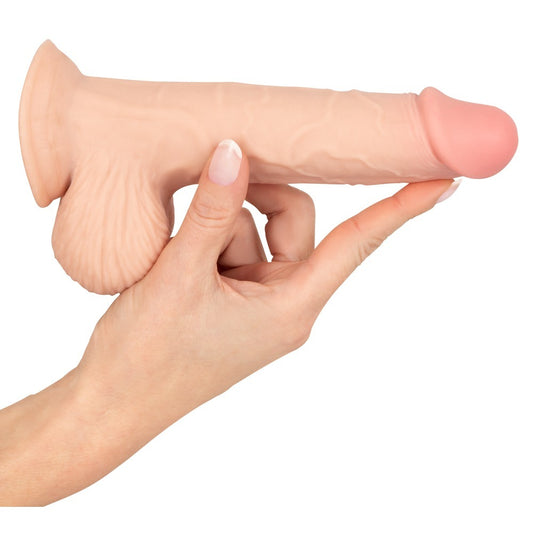 Realistic flesh-toned dildo held in hand
