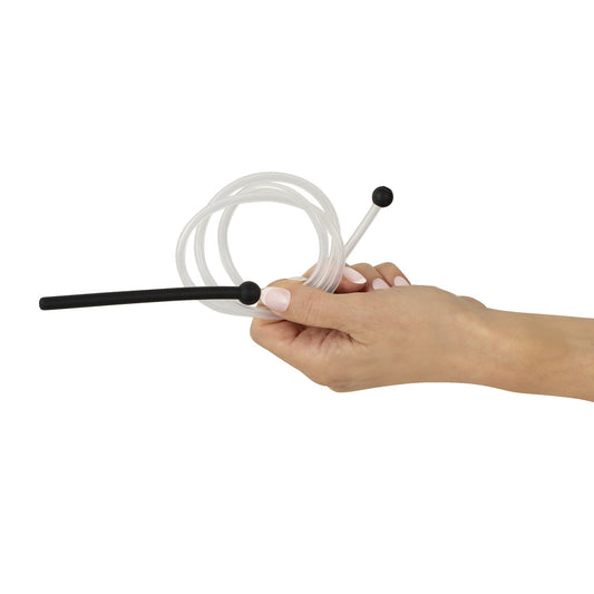 Clear tube with a black dilator held by a manicured hand