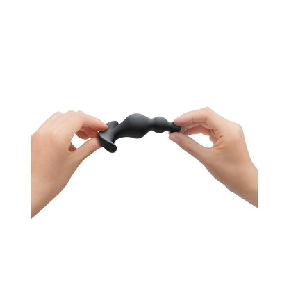 Dorcel training anal beads held between two hands.