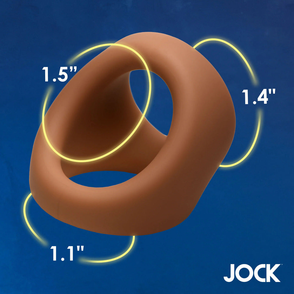 Tan silicone cock and ball ring with yellow measurements on blue.
