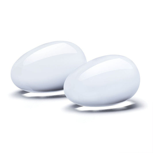 Two smooth, white glass Yoni eggs for pelvic floor health and pleasure.