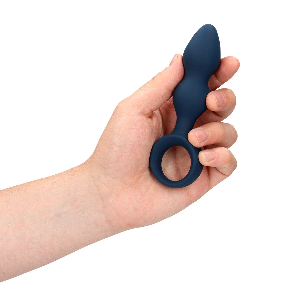 Man's hand holding blue anal plug sex toy.