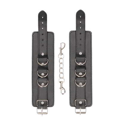 Pair of black leather wrist restraints with connecting chain.