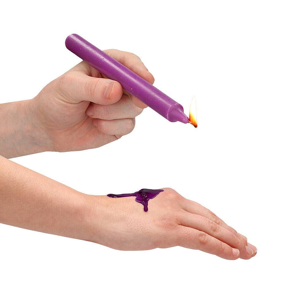 Teasing wax candle being dripped onto a hand.