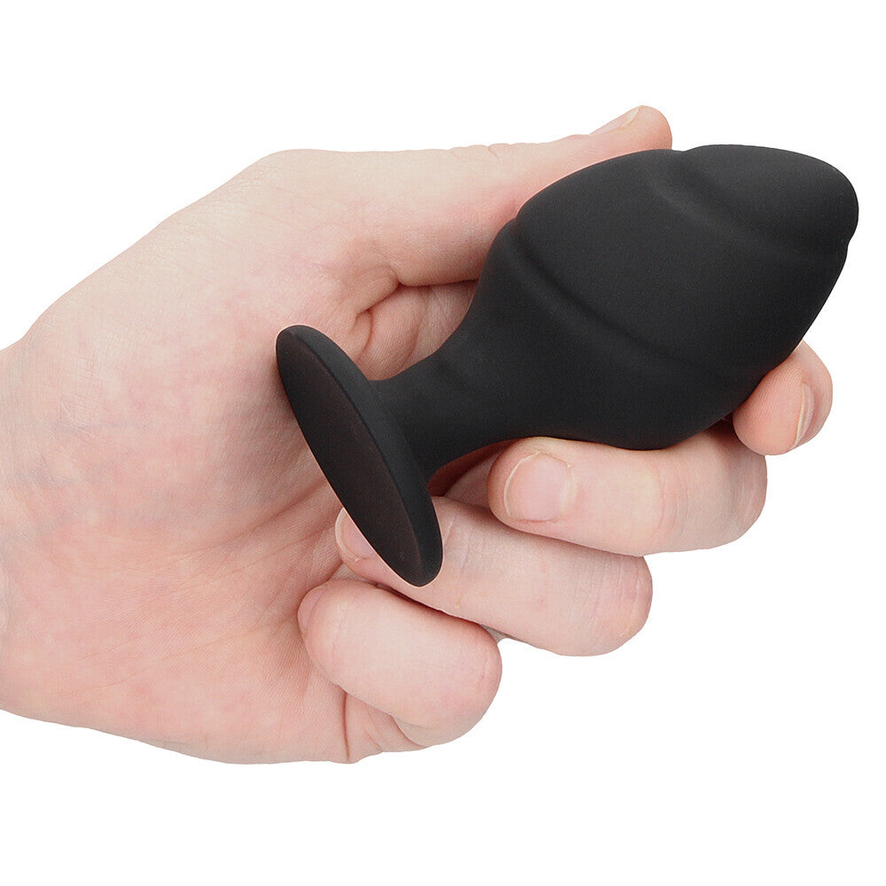 Black silicone butt plug held in hand.