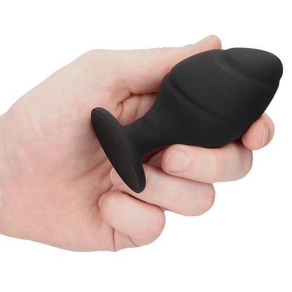 Black silicone butt plug held in hand.