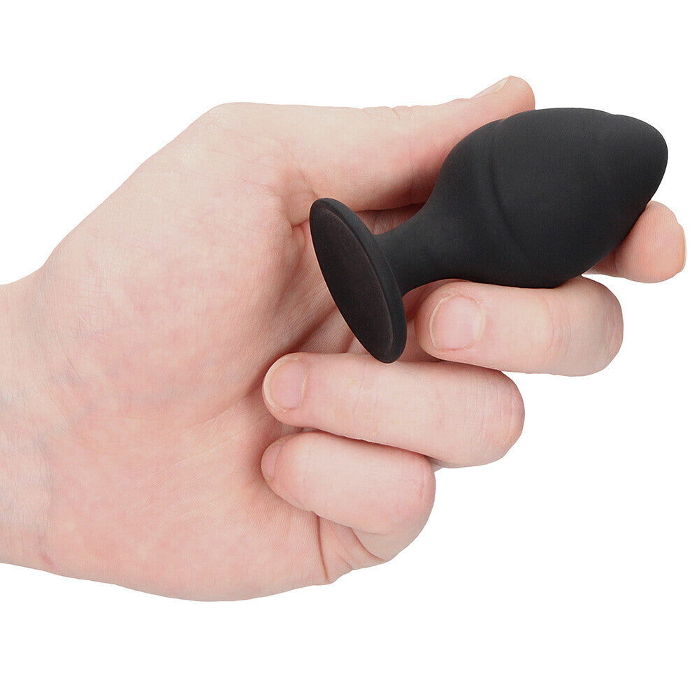 Black silicone butt plug held in hand.