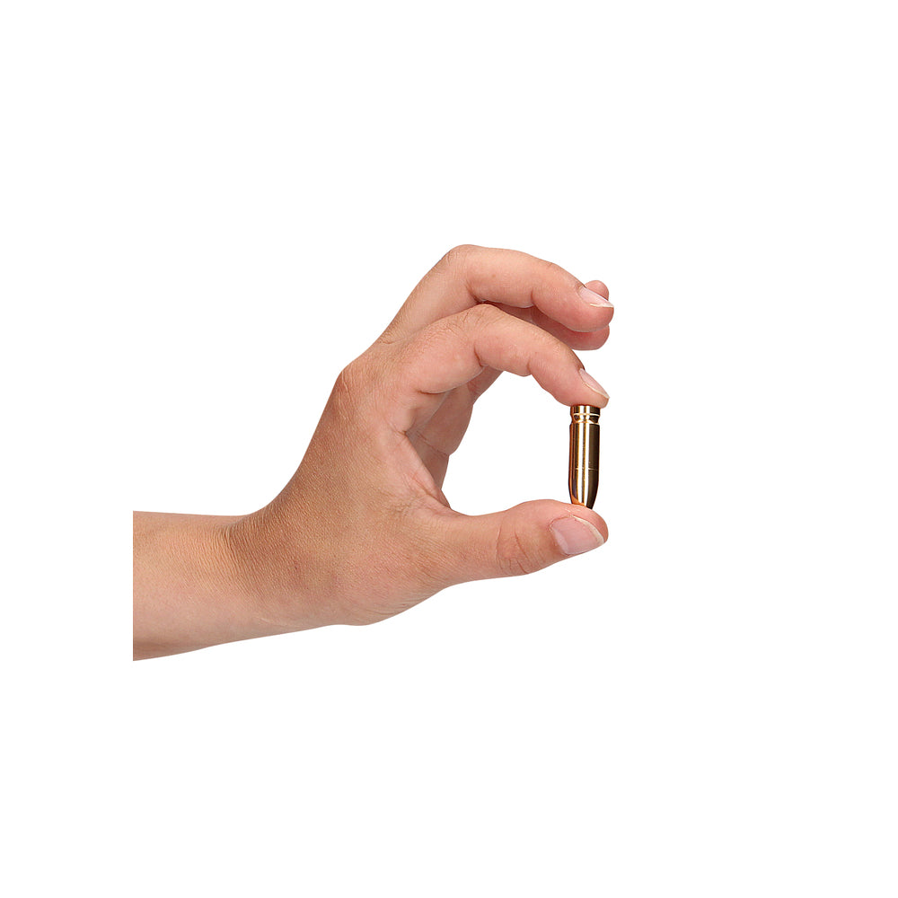 Gold bullet nipple clamp held in hand.
