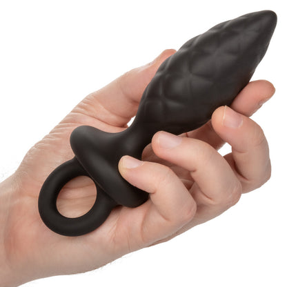 Silicone pleasure: a dark, intriguing plug, held in a hand, promising sensual exploration. A touch naughty, beautifully smooth.
