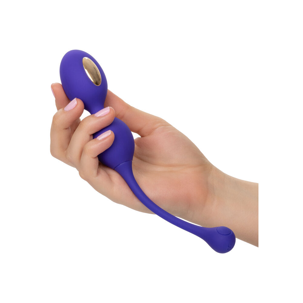 A hand holding a violet kegel exerciser.
