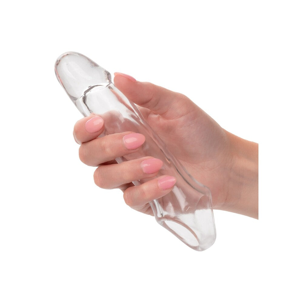 Clear penis extension sleeve held in hand.