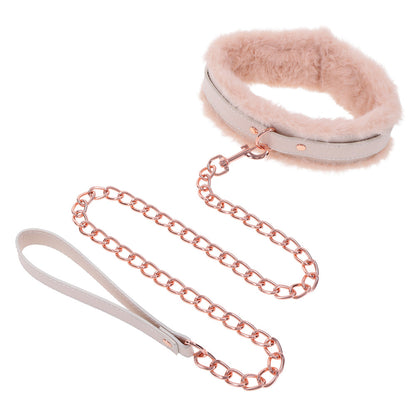 Flirty fur collar with rose gold chain leash from Sportsheets. Playfully explore your sensual side with this delightful accessory.