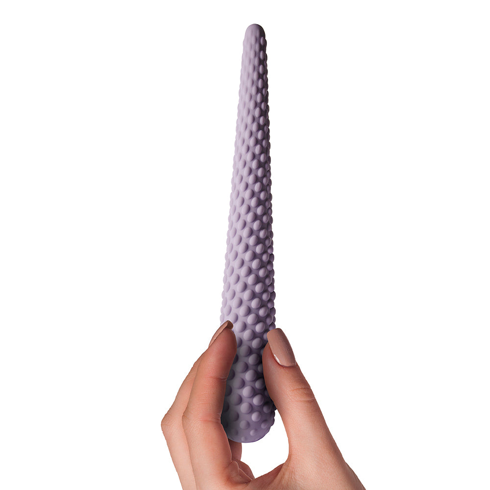 Lilac dilator with textured nodules held in hand.