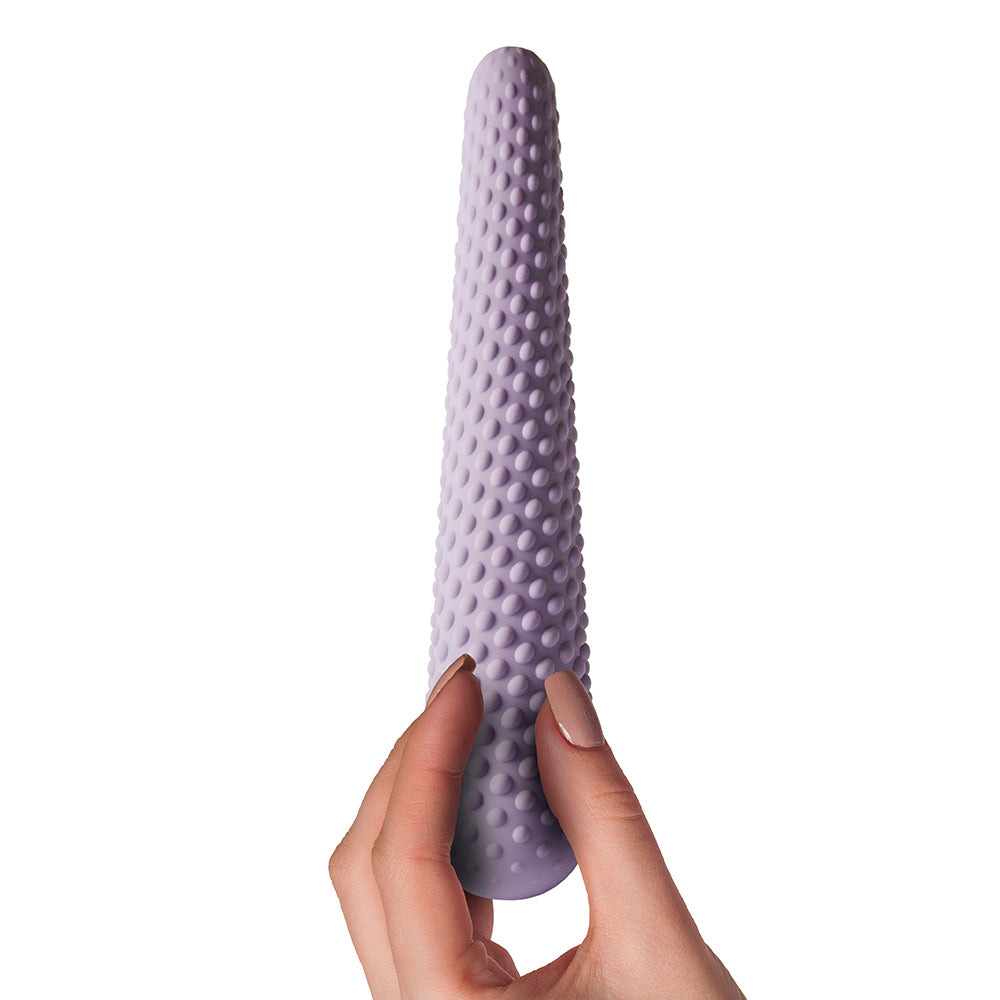Lilac dilator with bobbles, held by manicured hand.